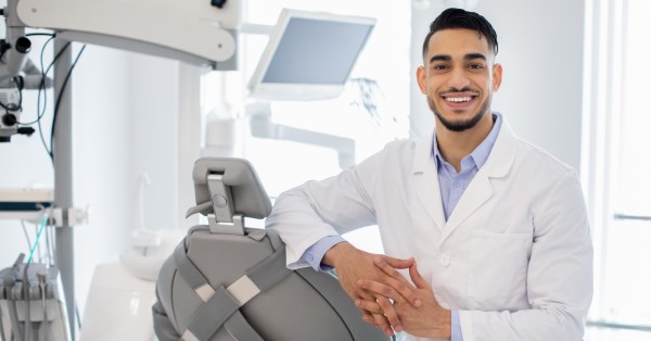 Smiling dentist in a modern dental clinic, representing a dentist near me in Garland for trusted local dental care.