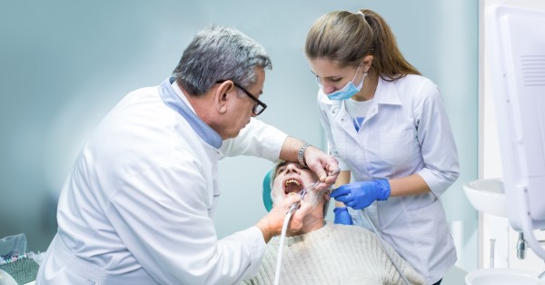 Emergency dentistry in Garland providing urgent dental care as a dentist and assistant treat a patient during an emergency visit.